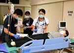 搬送患者を処置する職員ら
