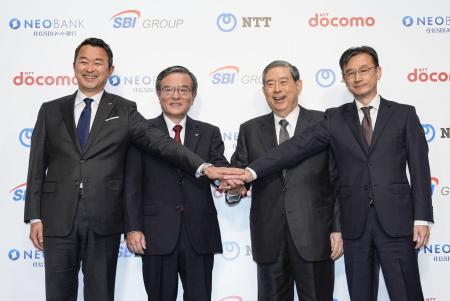　記者会見で写真に納まるＮＴＴドコモの前田義晃社長（左端）、ＳＢＩＨＤの北尾吉孝会長兼社長（左から３人目）ら＝２９日午後、東京都内のホテル