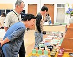 お気に入りの作品をじっくり探す来場者ら＝１１日、倉吉市上井町１丁目の日本海新聞中部本社ホール