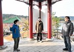 スタッフ（左）の説明を受ける映像制作関係者ら