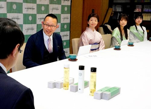 鳥取産ラベンダーを使ったヘアケア商品と宿泊施設での事業を説明する寺田社長（左から２人目）＝３１日、鳥取県庁