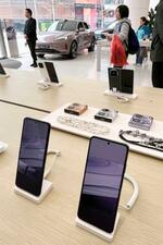 　華為技術の販売店に展示されたスマートフォンと自動運転システムを搭載した車（奥）＝３月、北京（共同）