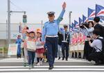 　保育園児らと横断歩道を渡る東京空港署の荒川明弘署長＝２６日午前、東京都大田区