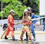 放水体験に臨む参加者。水圧の強さを感じながら放水作業に取り組んだ＝２５日、新温泉町今岡の美方広域消防本部