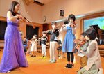 バイオリン演奏に挑戦する子どもたち＝２６日、琴浦町のまなびタウンとうはく