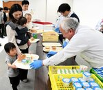 授業後の給食で牛乳やヨーグルトを受け取る参加者ら