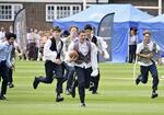 　競技発祥２００周年イベントでウィリアム・ウェブ・エリス少年がボールを抱えて走り出した逸話を再現するラグビー校の生徒たち＝６月２４日、英ラグビー（共同）