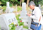 先祖が眠る墓前で静かに手を合わせる岡本さん＝１８日、倉吉市円谷町