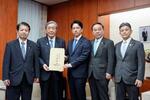 　自民党の食料安全保障強化本部長の森山幹事長（左から２人目）から決議書を受け取る小泉農相（中央）＝２日午後、農水省