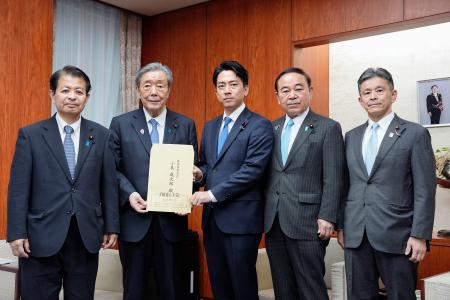 　自民党の食料安全保障強化本部長の森山幹事長（左から２人目）から決議書を受け取る小泉農相（中央）＝２日午後、農水省