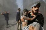 　イスラエル軍の空爆で負傷した子どもを運ぶパレスチナ人男性＝１０月２６日、ガザ地区南部ハンユニス（ロイター＝共同）