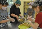 和気あいあいとおこわ作りに取り組む参加者＝２１日、若桜町中原の池田分館
