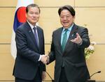 　韓国の金暎浩統一相（左）と握手する林官房長官＝１０日午後、首相官邸