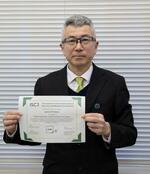 　国際的な情報セキュリティー資格の合格証明書を手にする下末昇一警部補（画像の一部を加工しています）