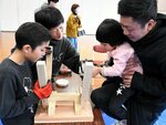 力を合わせてベンチを組み立てる参加者