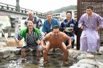 おなじみのポーズで元気な三朝温泉をアピールするとにかく明るい安村さん（前列右）と平井知事（同左）ら＝８日、鳥取県三朝町三朝の河原風呂