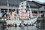 読経や御詠歌の流れる中、多くの人に見送られて港を出る精霊船＝１６日夕、新温泉町居組