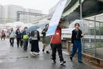　尼崎ＪＲ脱線事故の負傷者らでつくる「空色の会」が開催したメモリアルウオーク。奥はＪＲ福知山線＝１３日午後、兵庫県尼崎市