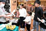 店員（左）から認証マークの説明を受ける参加者