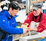 城崎マリンワールドの職員（左）に受け渡された体が真っ白な松葉ガニ＝２８日、香美町香住区香住の「かに市場」