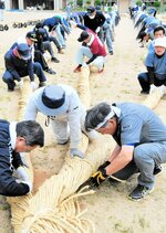 わら縄１５０本の束をねじり上げていく参加者＝３１日、新温泉町湯の温泉小グラウンド