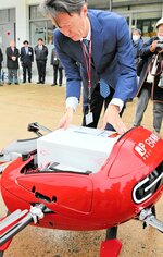 新型機に荷物を搭載する日本郵便の社員＝豊岡市出石町