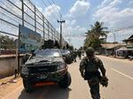 　シュエココを支配する武装勢力の戦闘員と車両。リゾート施設の広告看板もあった＝３月１２日（共同）