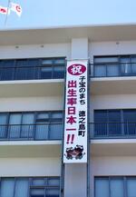 　「出生率日本一！！」などと書かれた鹿児島県徳之島町役場の垂れ幕＝５月