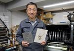 　活版機で印刷した紙製品を手にする中西弘和さん