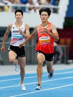 　男子２００メートル決勝で力走する鵜沢飛羽（右）。２０秒１２で２連覇を果たした＝亀尾（共同）