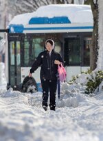 雪が積もった歩道を歩く市民＝25日午前8時55分ごろ、米子市両三柳