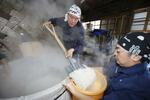 　蒸し上がった酒米を釜から取り出す作業＝１１月、茨城県大洗町の「月の井酒造店」