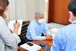 報道陣の取材に応じる藤縄県議（中央）＝１９日、鳥取県庁