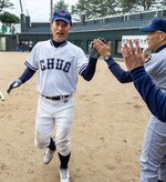 生還　ホームインした選手をハイタッチで迎える