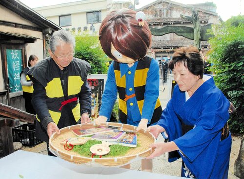 絵馬と台本を奉納する（左から）岡空副会長、着ぐるみの鬼太郎、京久野代表＝１７日、境港市大正町の妖怪神社