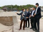 　石川県輪島市内の隆起した海岸を視察する地方創生支援官の（左から）佐藤由紀子さん、加藤太郎さん、坂本和也さん＝２６日午後