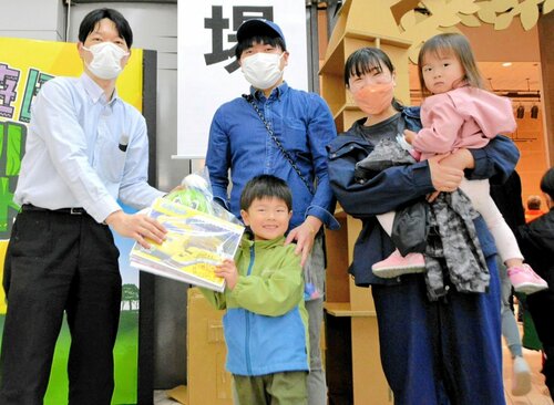 ３万人目の入場者となり、掃部館長（左）から記念品を受け取る大川颯稀ちゃん（中央）＝７日、境港市の夢みなとタワー