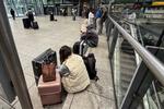 　２１日、ロンドンのヒースロー空港で待機する人たち（ロイター＝共同）