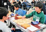 真剣な表情で対局する参加者たち＝２２日、香美町香住区の香住文化会館
