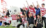 代表チームの活躍を祈念してキャラバン隊とともに気勢を上げるラグビーファン＝２９日、湯梨浜町南谷のハワイ夢広場