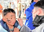 お参りの前に顔に墨を塗る男児ら＝７日、香美町香住区沖浦