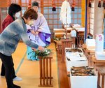 古筆が置かれた祭壇に玉串をささげる山田会長＝２９日、米子市博労町２丁目の勝田神社