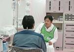 　東京電力福島第１原発の免震重要棟内で医師の問診を受ける作業員（手前）＝２０１１年６月（東京電力提供）