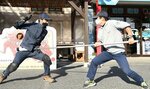 刃物を持った犯人役を刺股で制圧する社員（右）＝９日、岩美町大谷の山陰松島遊覧