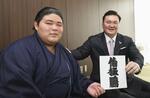  新入幕が決まり、新しいしこ名が書かれた色紙を持つ伯桜鵬（左）と宮城野親方＝２６日、愛知県豊田市の宮城野部屋宿舎（代表撮影） 
