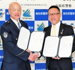 連携協定を交わした笠田生活安全部長（左）と増島支店長＝２９日、鳥取県警本部