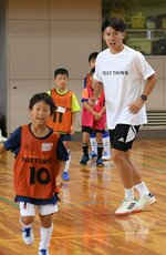 子どもたちと一緒に体を動かしてプレーの助言を行う太田さん（右）＝３０日、米子市東福原８丁目の米子産業体育館