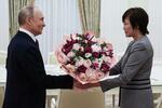 　２９日、モスクワのクレムリンで安倍昭恵さん（右）に花束を渡して歓迎するロシアのプーチン大統領（ロシア大統領府提供・タス＝共同）