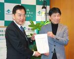 　浅尾環境相（左）に要望書を手渡す山本一太群馬県知事＝２６日午後、環境省