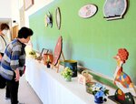 井上さんのトールペイント作品を鑑賞する来館者